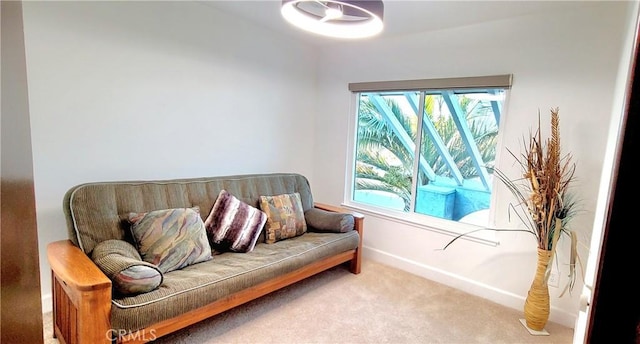 living area featuring carpet flooring and baseboards