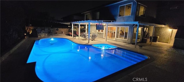 view of pool featuring a patio, a pool with connected hot tub, and a pergola