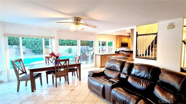 living area with light tile patterned flooring and a ceiling fan