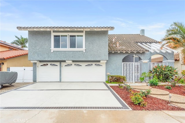 view of front of house with stucco siding, an attached garage, a tile roof, and driveway