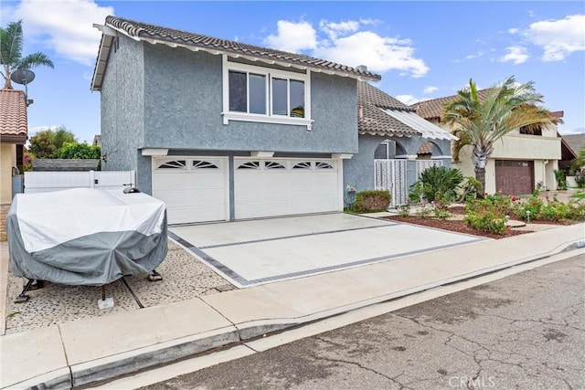 view of front of house with stucco siding, driveway, an attached garage, and a tile roof