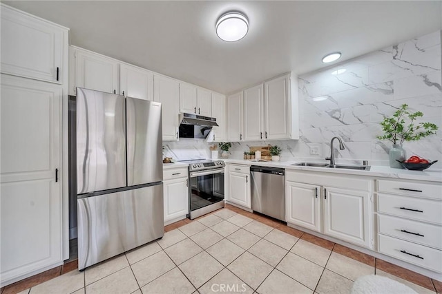 kitchen featuring light countertops, appliances with stainless steel finishes, a sink, and white cabinets