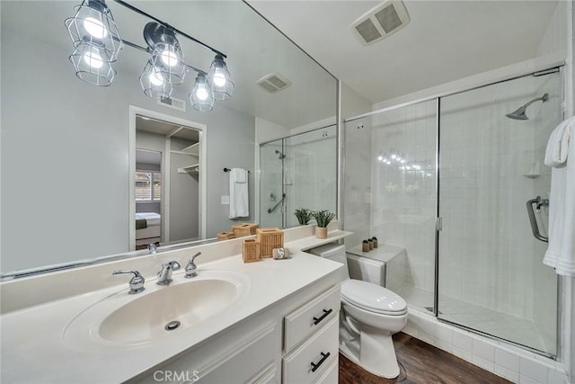 bathroom with a stall shower, visible vents, vanity, and wood finished floors