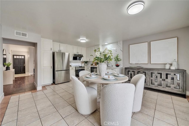 dining space with light tile patterned floors, baseboards, and visible vents