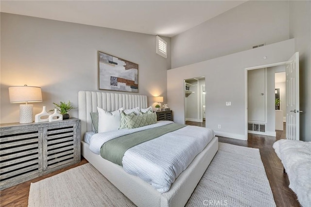 bedroom featuring high vaulted ceiling, visible vents, baseboards, and wood finished floors