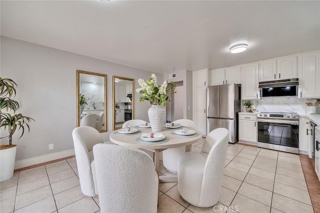 dining space with visible vents, baseboards, and light tile patterned floors