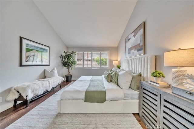 bedroom featuring vaulted ceiling and dark wood-type flooring