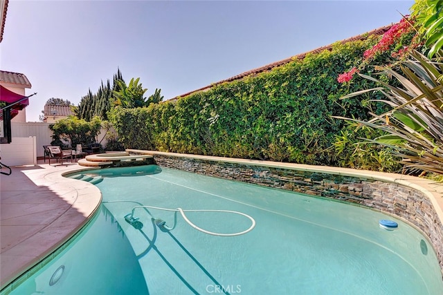 view of swimming pool featuring a patio area, a fenced backyard, a fenced in pool, and an in ground hot tub