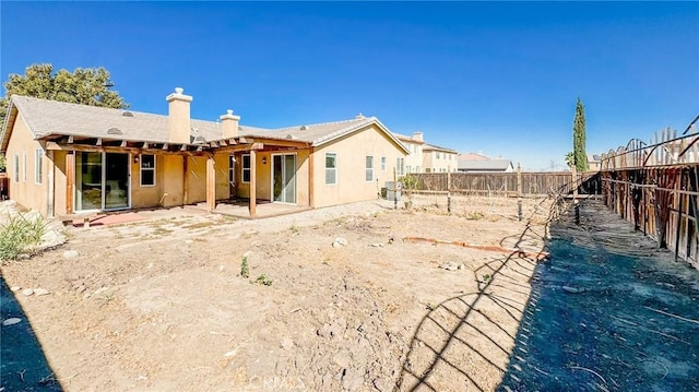 back of house with a patio area, a fenced backyard, and a chimney