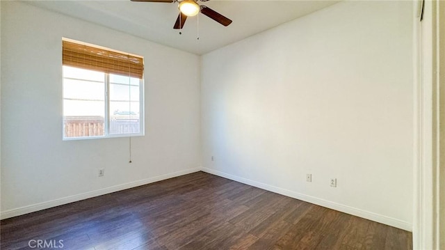 spare room with dark wood-style floors, baseboards, and a ceiling fan