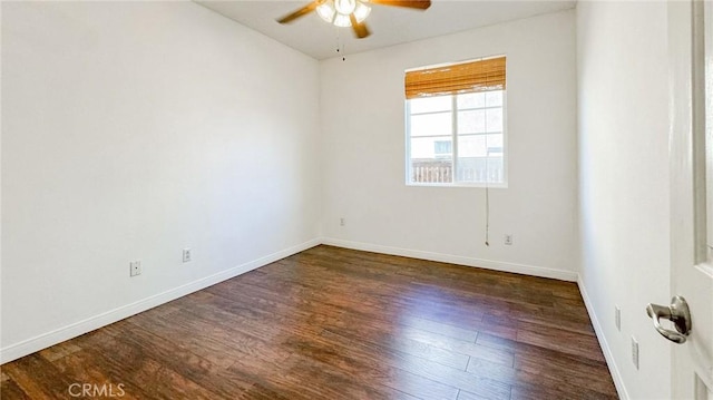 spare room with ceiling fan, dark wood finished floors, and baseboards