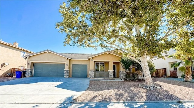 view of front of property featuring concrete driveway, stone siding, an attached garage, fence, and stucco siding