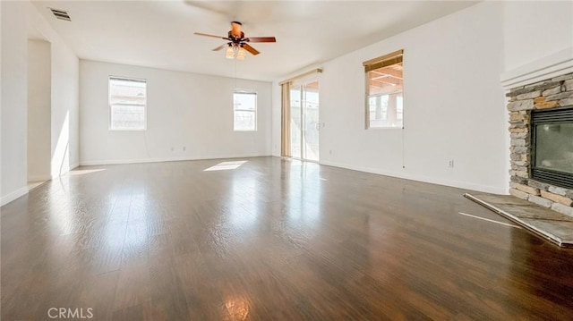 unfurnished living room with ceiling fan, a fireplace, baseboards, and wood finished floors