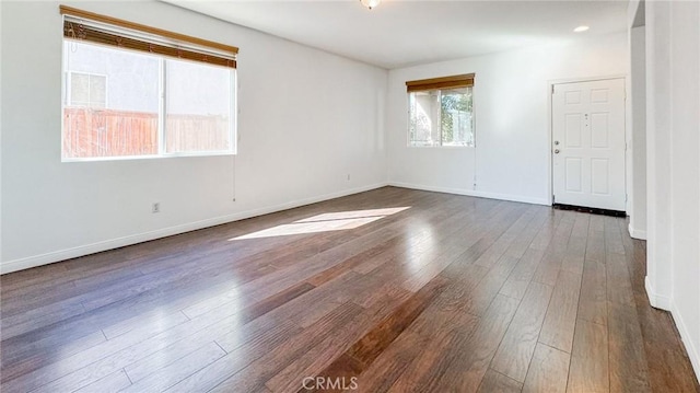 spare room with dark wood-style floors and baseboards