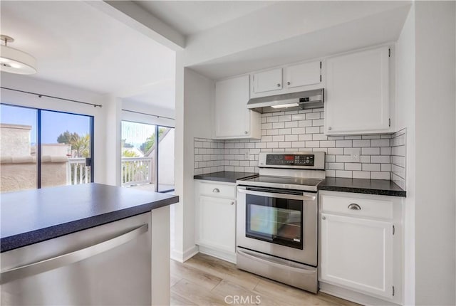 kitchen featuring dark countertops, stainless steel appliances, decorative backsplash, and under cabinet range hood