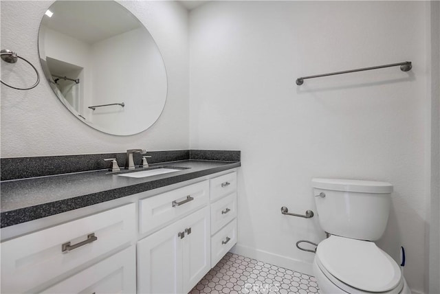 bathroom featuring vanity, toilet, and baseboards
