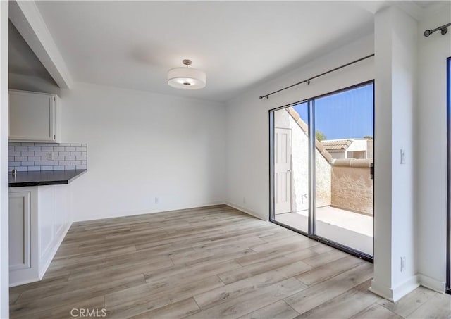 unfurnished dining area featuring light wood-style flooring