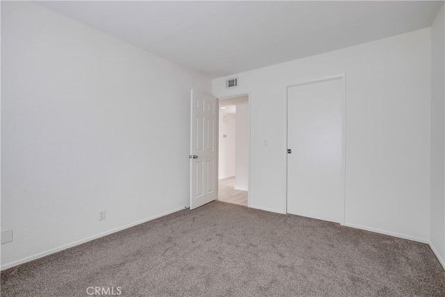 unfurnished bedroom featuring carpet floors, baseboards, and visible vents