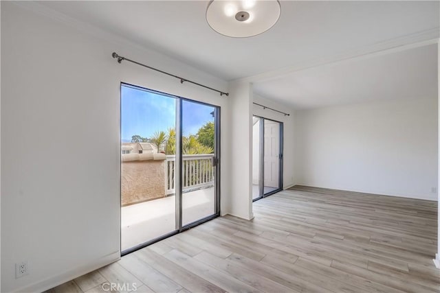 spare room with light wood finished floors and ornamental molding