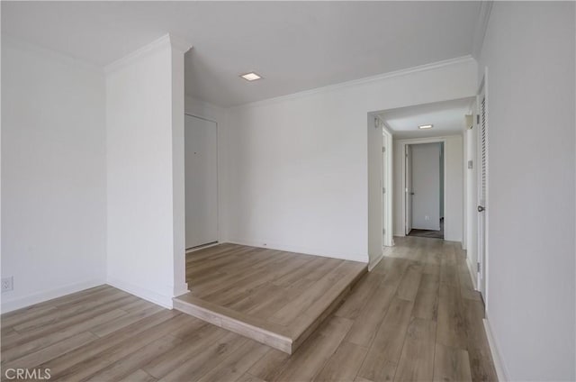 unfurnished room featuring baseboards, crown molding, and wood finished floors