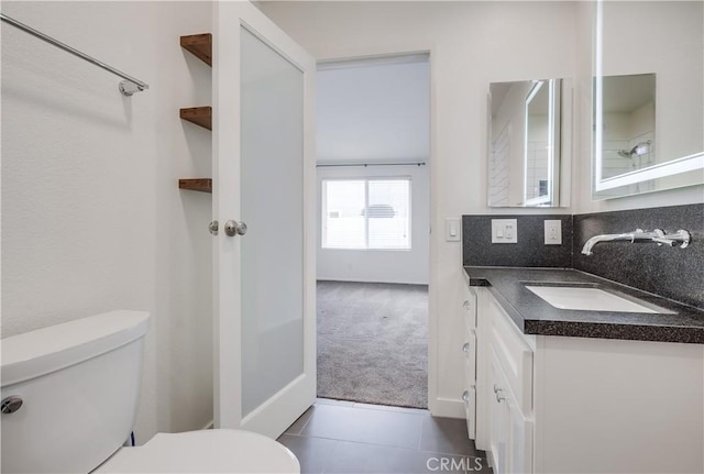 bathroom with toilet, tile patterned flooring, and vanity
