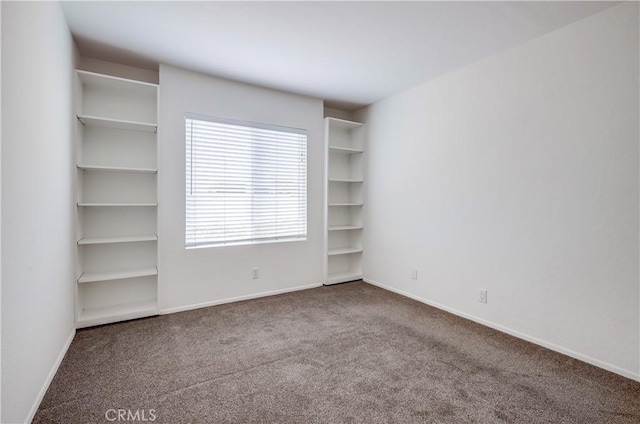 empty room with baseboards and carpet