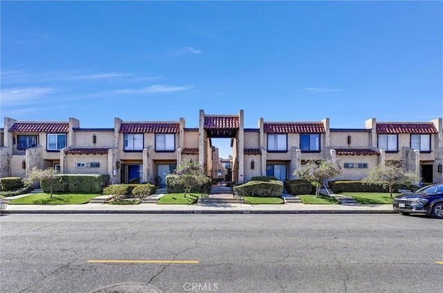 multi unit property with a tile roof and stucco siding