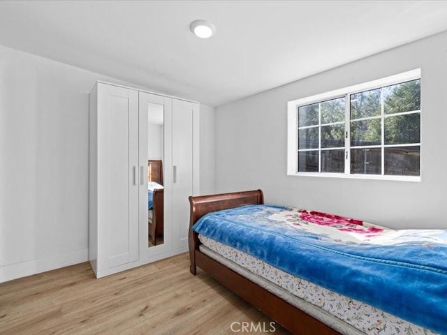 bedroom with light wood-type flooring and baseboards