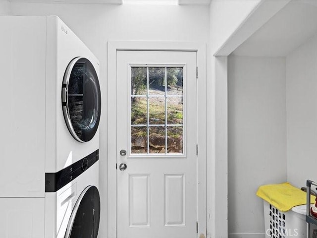 clothes washing area featuring stacked washer / drying machine and laundry area