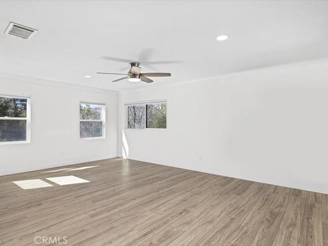 empty room featuring recessed lighting, visible vents, crown molding, and wood finished floors