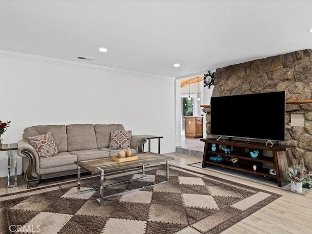 living room with ornamental molding, recessed lighting, visible vents, and wood finished floors