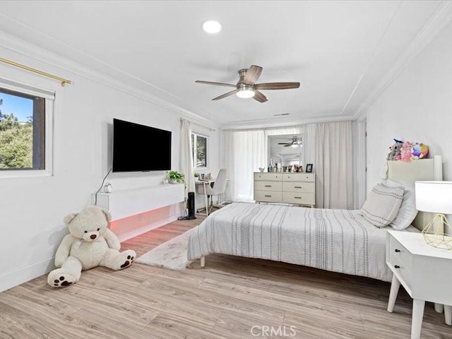 bedroom featuring multiple windows, wood finished floors, a ceiling fan, and crown molding