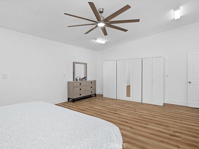 bedroom with ceiling fan, baseboards, vaulted ceiling, and wood finished floors