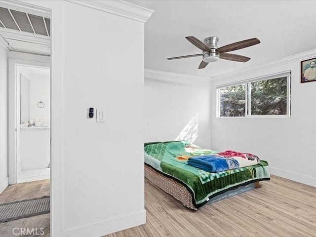 bedroom featuring baseboards, visible vents, crown molding, and light wood finished floors