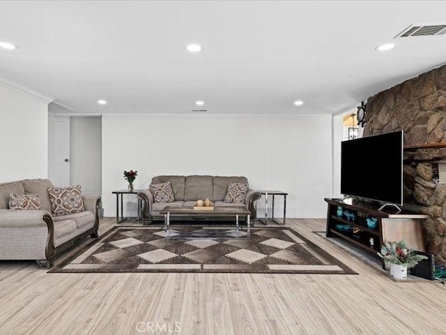 living room with ornamental molding, recessed lighting, visible vents, and wood finished floors