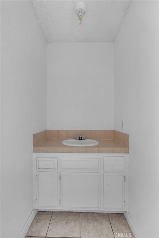 bathroom featuring vanity, a textured ceiling, and tile patterned floors