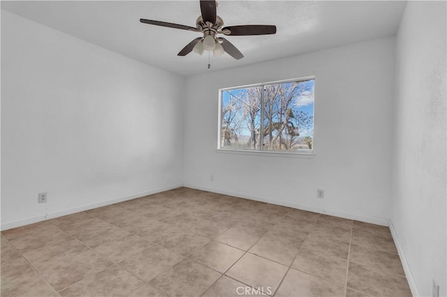 empty room with a ceiling fan and baseboards