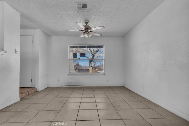 unfurnished room featuring a ceiling fan, visible vents, a textured ceiling, and baseboards