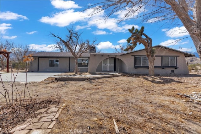 back of property with a chimney and stucco siding