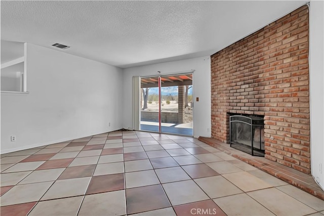 unfurnished living room featuring tile patterned flooring, a fireplace, visible vents, and a textured ceiling