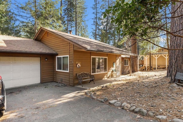 chalet / cabin featuring a garage, driveway, fence, and roof with shingles