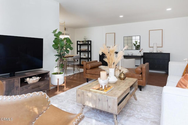 living room with recessed lighting, visible vents, and wood finished floors