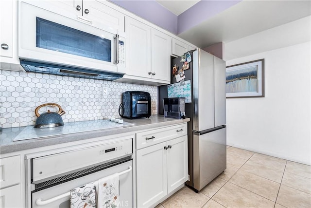 kitchen featuring light tile patterned flooring, white appliances, light countertops, and white cabinetry