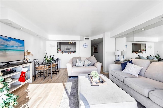 living room with light wood-style floors and visible vents