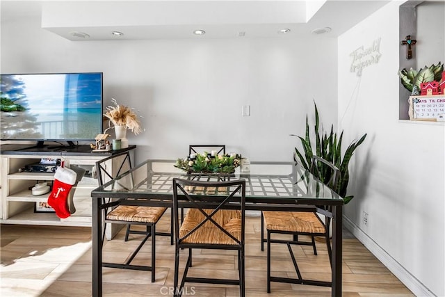 dining space featuring wood finished floors and baseboards