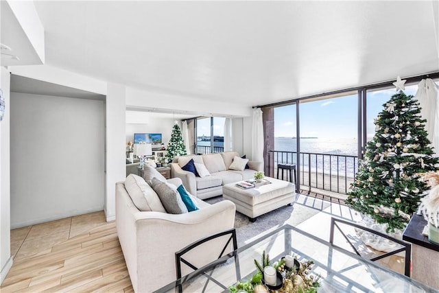 living area with floor to ceiling windows, a wealth of natural light, and wood finished floors