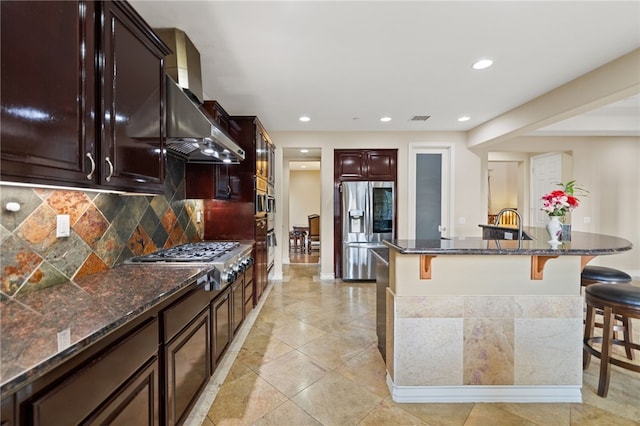 2514 Bulrush Cir, Corona, CA 92882 - kitchen featuring appliances with stainless steel finishes, a kitchen breakfast bar, recessed lighting, decorative backsplash, and dark stone counters