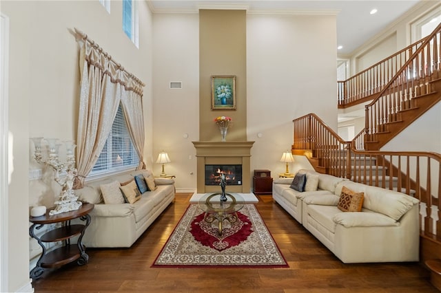 2514 Bulrush Cir, Corona, CA 92882 - living area featuring stairs, wood finished floors, a high ceiling, a glass covered fireplace, and crown molding