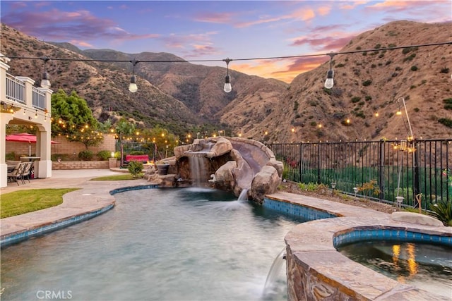 2514 Bulrush Cir, Corona, CA 92882 - pool at dusk with a mountain view, fence, a patio area, and a pool with connected hot tub