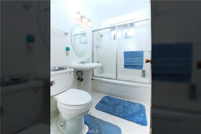 full bath featuring shower / bath combination with glass door, toilet, and tile patterned floors